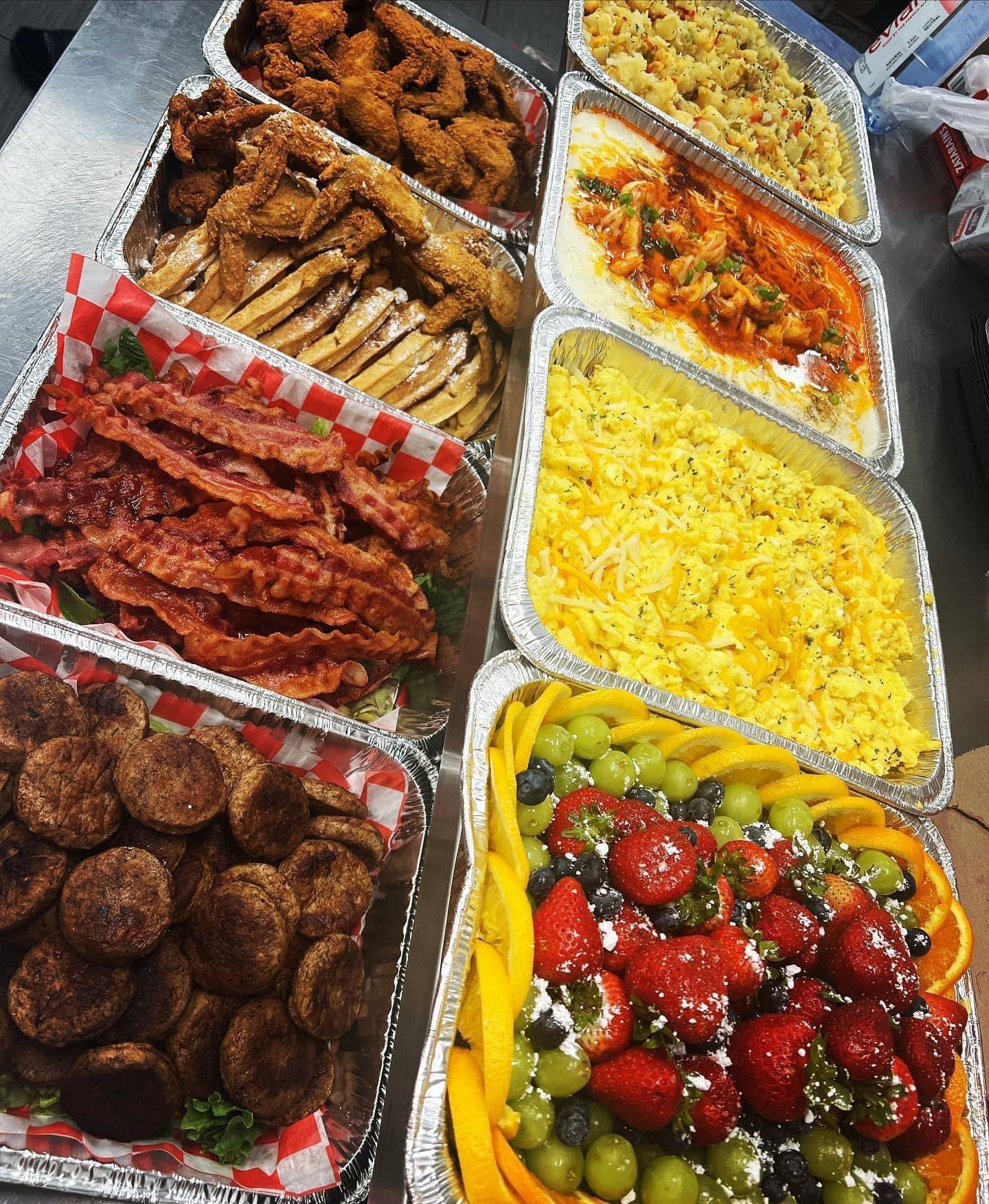 Madea's full family-style buffet spread with wings, bacon, sausage, eggs, potato salad and fresh fruit